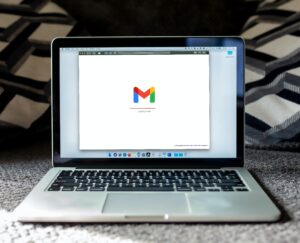 An open laptop featuring the Gmail logo, highlighting the importance of email marketing in engaging beauty salon customers.